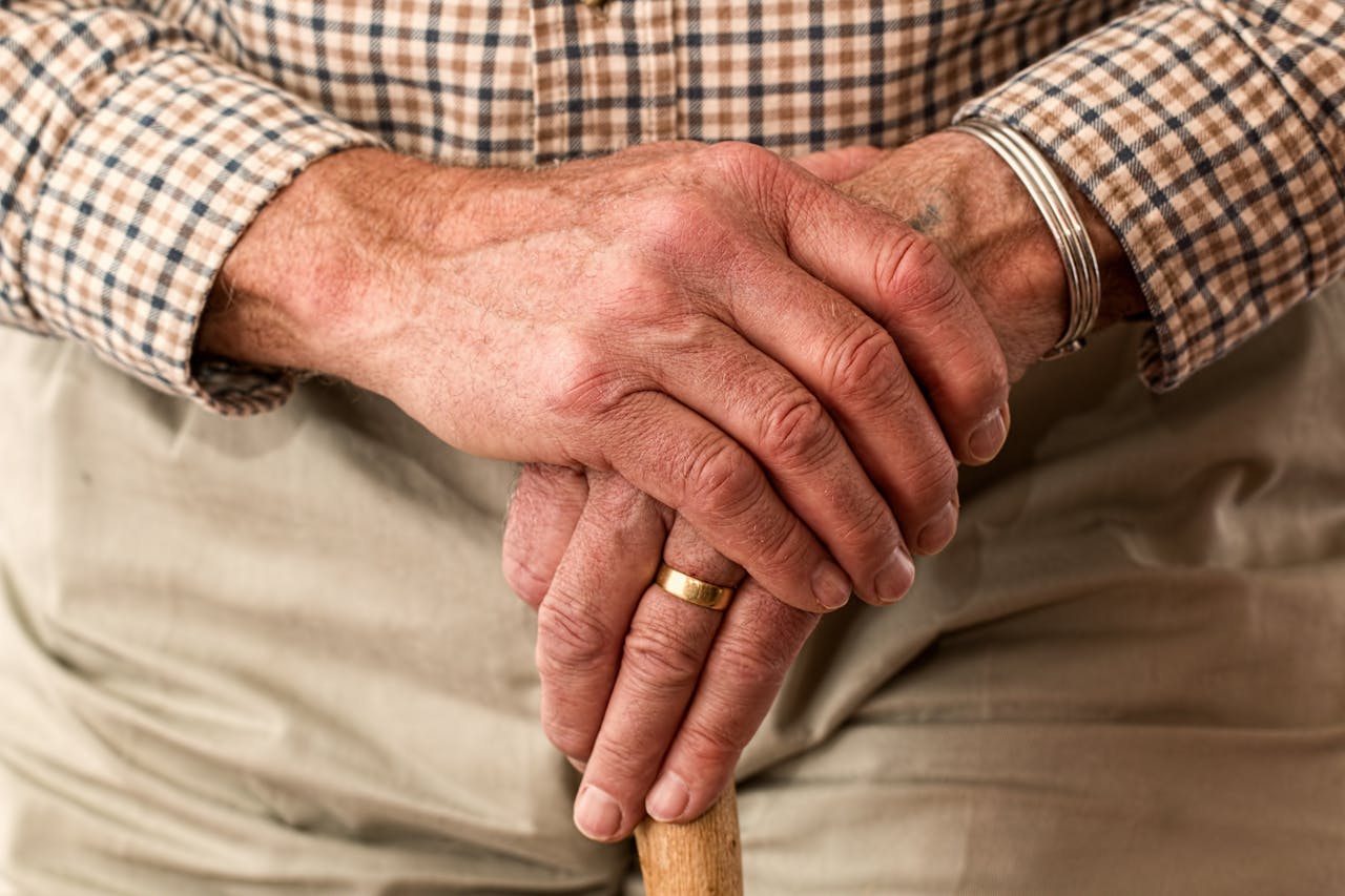 our-services-2 A detailed image of elderly hands clasping a wooden cane, symbolizing aging and support.